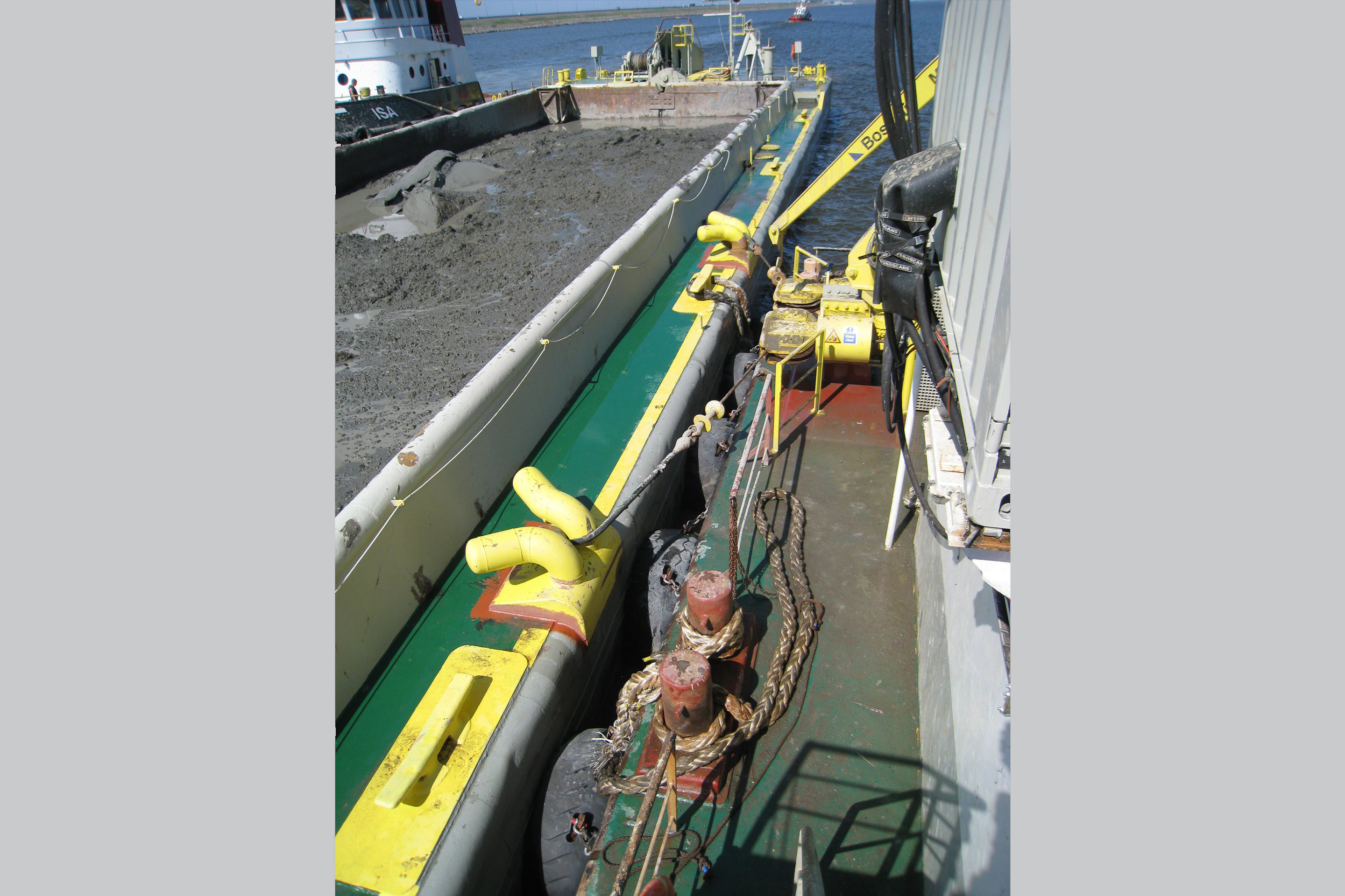 Specially developed constant tension (CT) winches roll up the line and pull the barge to the backhoe